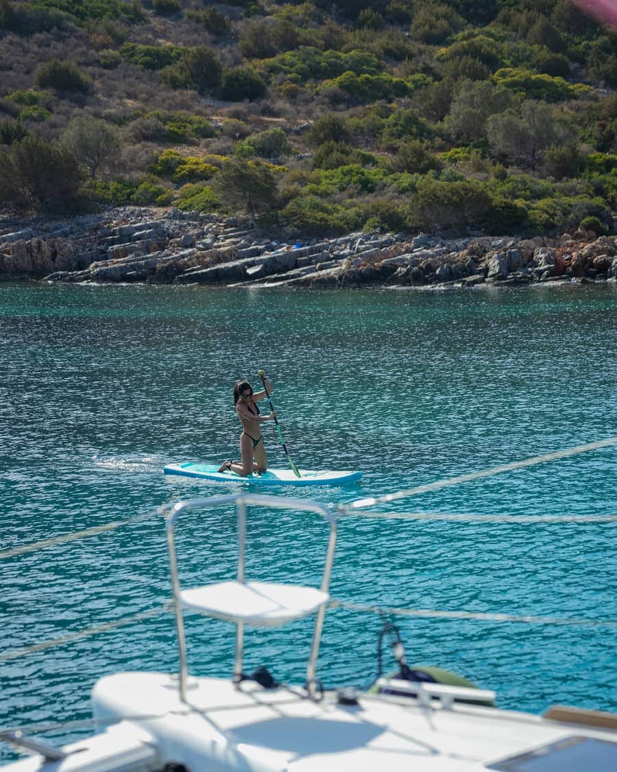 Paddleboarding in a calm turquoise cove during a sailing trip in Crete
