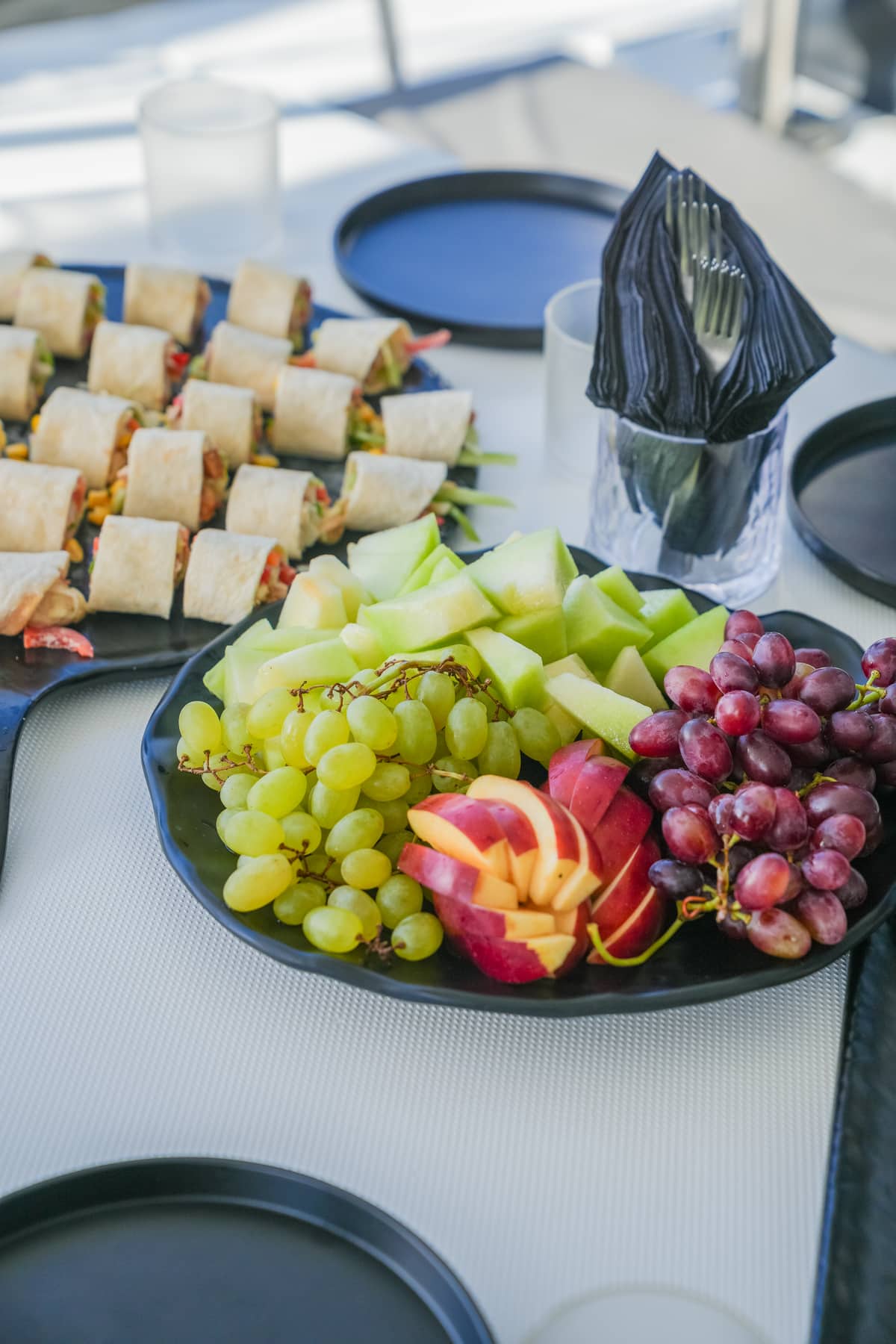 Fruit platters and light snacks laid out on a catamaran deck in Crete